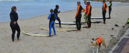 Projects Abroad’s surf coach going over the basics with children on the beach Projects Abroad volunteers being prepped to go out and surf during a lesson by our surfing coordinator
